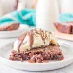 one piece of brownies in white plate with ice cream and chocolate fudge