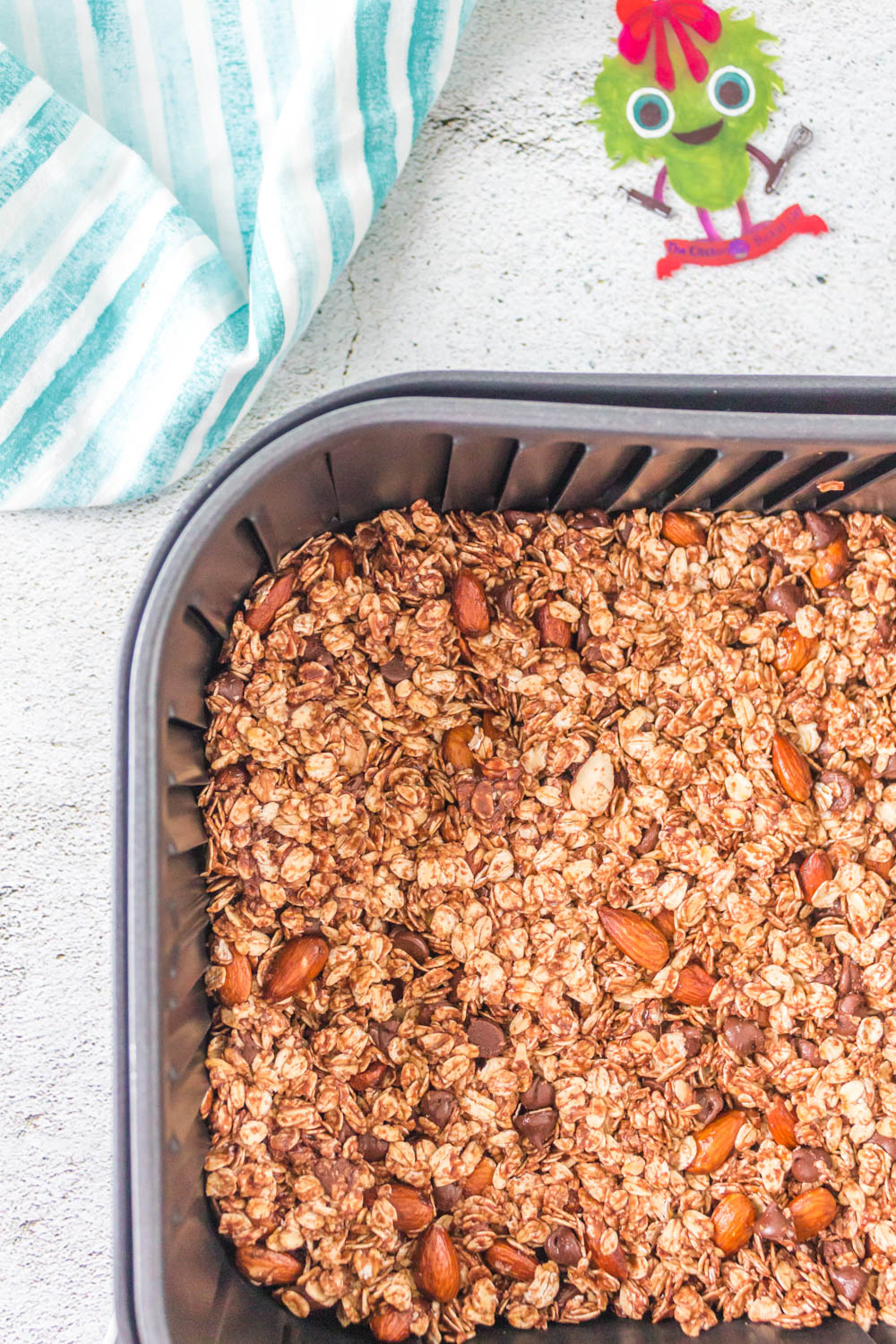 Nutella granola pressed into the air fryer basket before air frying.