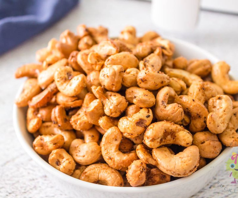 Roasted cashews in a white bowl center image
