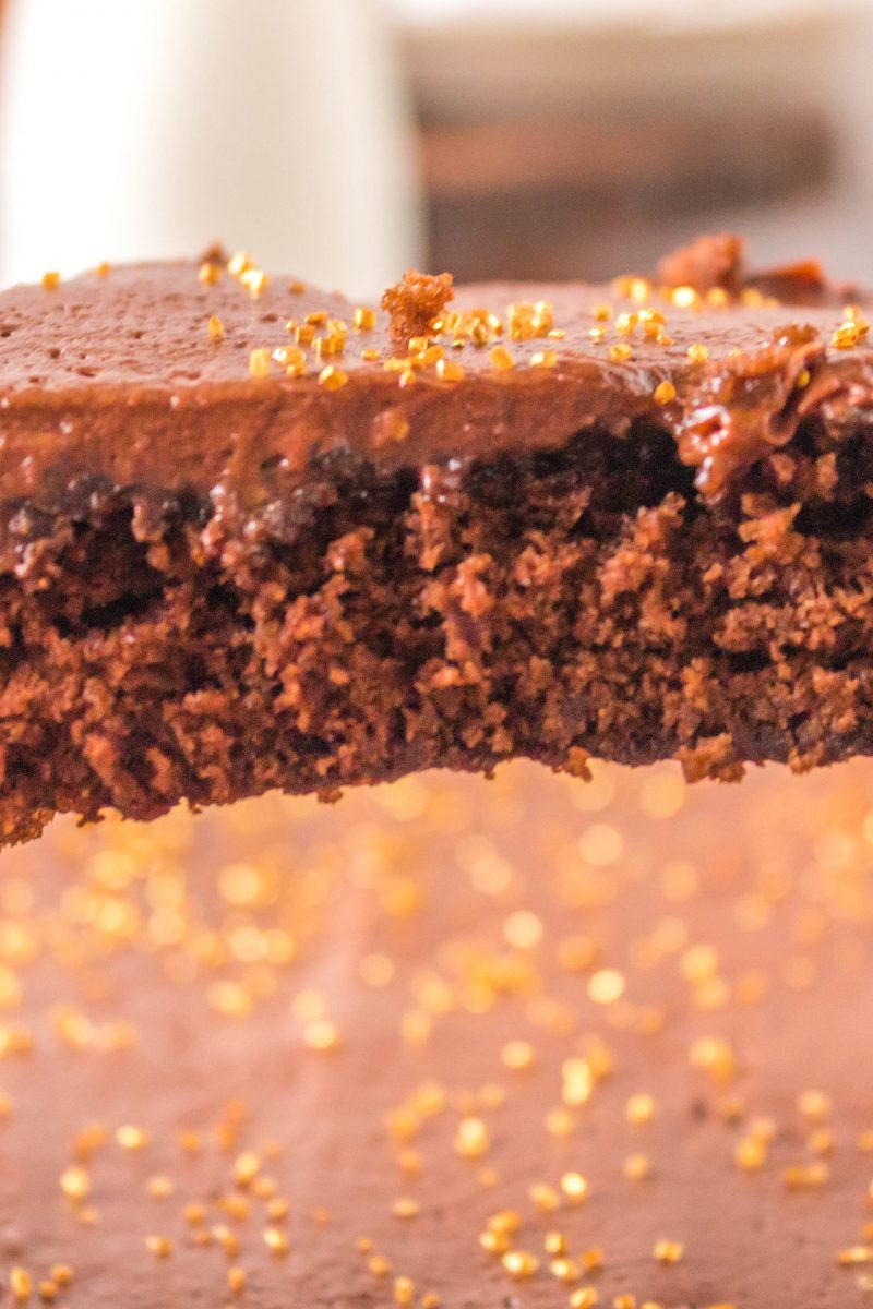 slice of chocolate cake in spatula above cake sheet