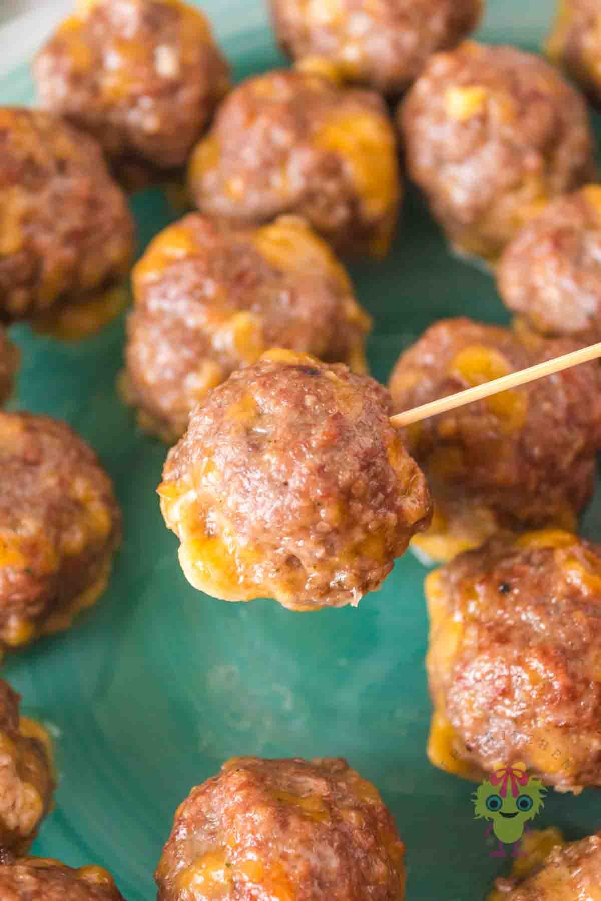 A mini cheeseburger, smoked meatball close-up showing how tender and cheesy it is.