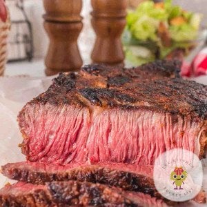 Big thick bone in ribeye steak sliced to show the perfect medium rare doneness.