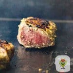 Showing how to cook steaks on a griddle to a pink medium rare. Sirloin steak on griddle with smoke rising.