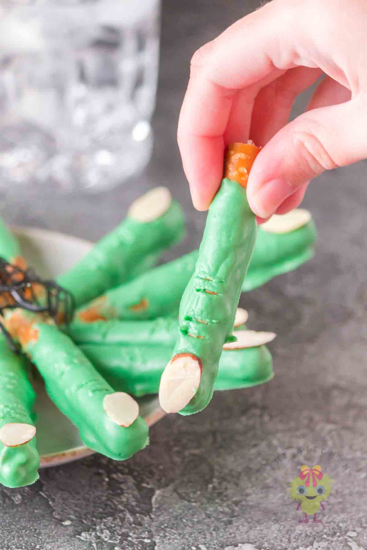 Get ready to cast a spell on snack time with these Halloween pretzels! The picture show a witch finger pretzel above a plate of witch finger pretzels. So grab your broomsticks and let’s get munching!