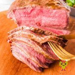 Smoked sirloin tip roast with Dijon mustard sauce marinade sliced and ready to serve. It is a perfect medium rare.