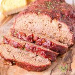 Sliced smoked meatloaf with BBQ sauce that has caramelized to form a crust. It is moist and tender.