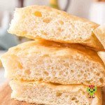 Homemade focaccia Genovese pieces stacked on top of each other. Each has a golden crust and airy bubble filled crumb.