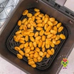 Seasoned air fried gnocchi coming out of the air fryer in the basket that are beautifully crispy and pillowy.