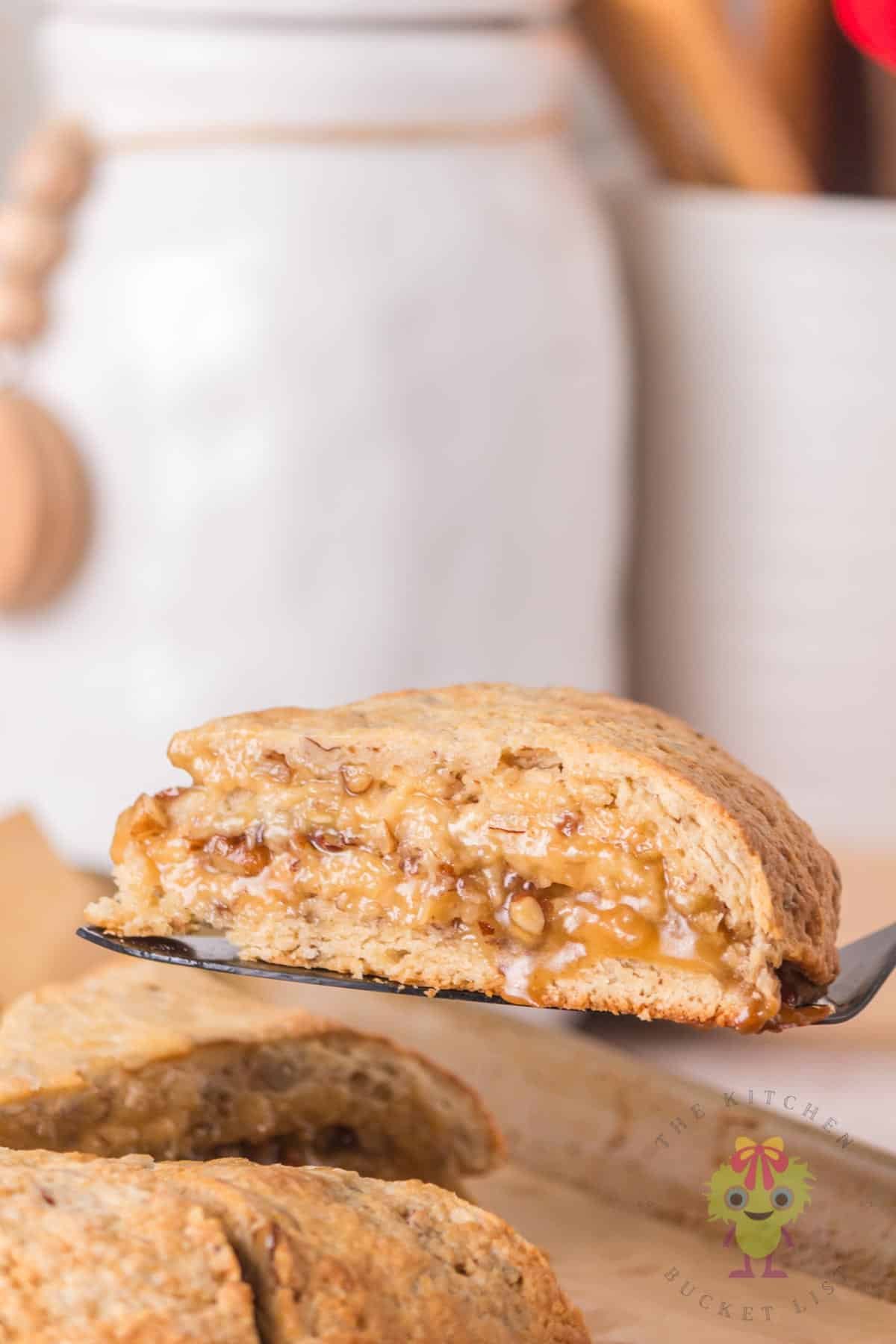 A pecan pie scone is being served from the rest, fresh and warm, straight from the oven.