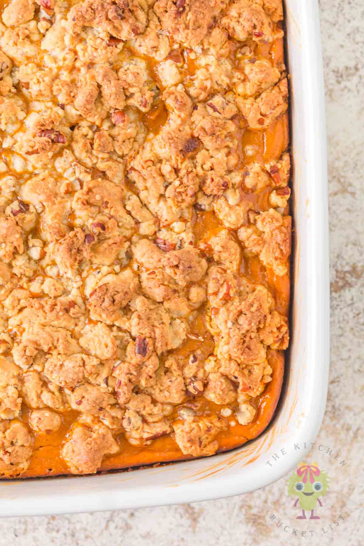 Beautifully baked pumpkin pie cake with its golden, crunchy pecan crumble. You can see how the edges and pumpkin custard are set.