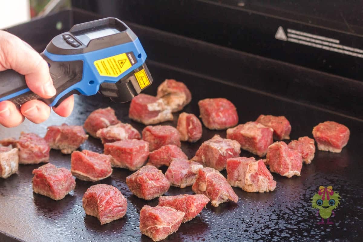 Showing how we use an instant-read thermometer to check the griddle's surface temperature. It is critical to have it at the proper temperature for perfect searing.