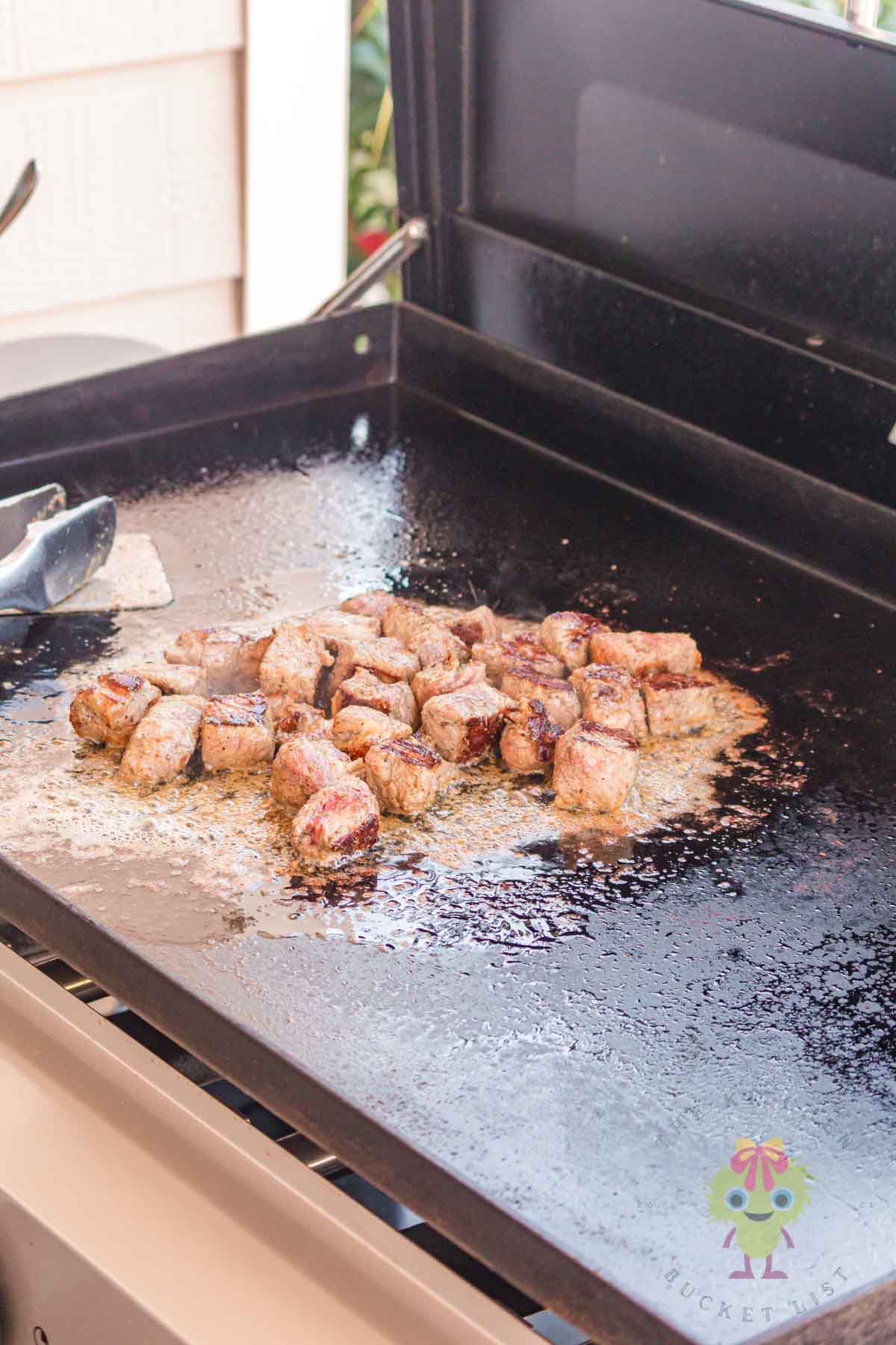 Showing how to do the garlic butter bath at the end of cooking on the griddle. It gives that extra hit of garlic and butter to go to the next flavor level.